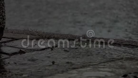 夏天街道路面上掉落的水滴和泥泞的水坑视频的预览图