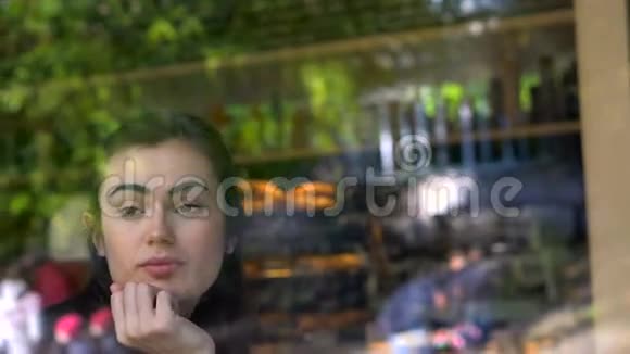 小女孩在咖啡馆的窗户里视频的预览图