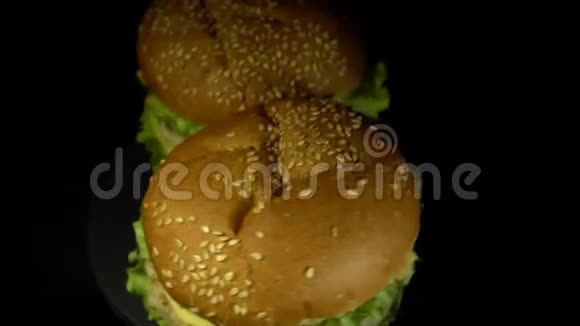 关闭两个汉堡旋转在黑色背景视频的预览图