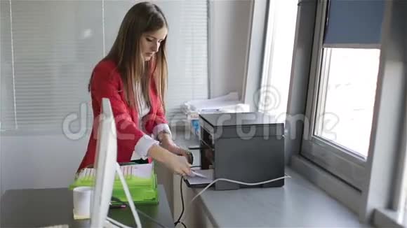 年轻漂亮的女人在复印机里复印文件视频的预览图