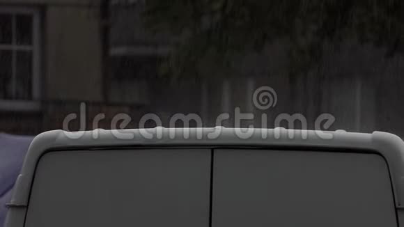 夏季雨天淋浴下的一辆现代灰色轿车视频的预览图