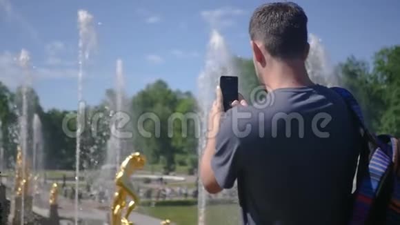 成年人在公园里为一个美丽的夏季喷泉拍照慢动作1920x1080全高清视频的预览图