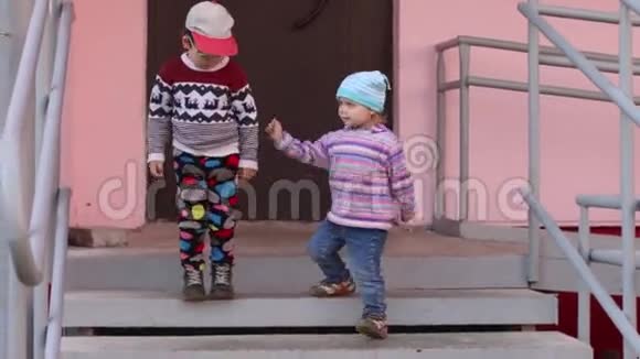 两个可爱的小朋友玩住宅楼入口楼梯视频的预览图
