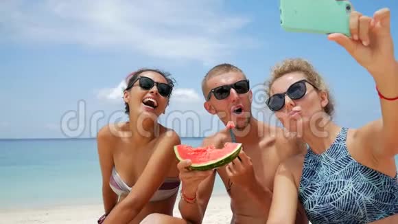快乐混合种族的一群朋友带着自拍吃着新鲜的西瓜海滩上有趣的素食主义者泰国视频的预览图