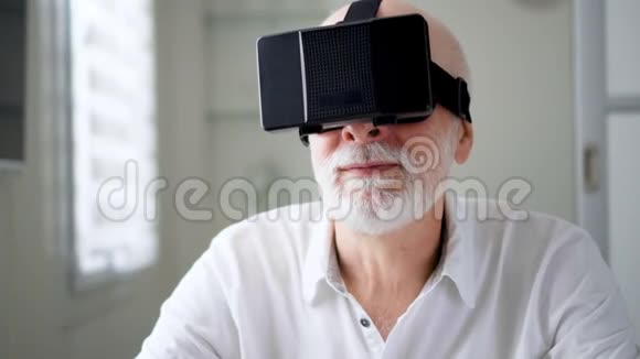 好看帅气的白衣资深男士在家使用VR360眼镜活跃的现代老年人视频的预览图