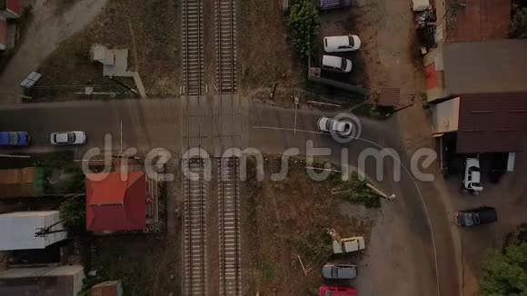 一列移动火车用汽车穿过沥青路的空中射击视频的预览图