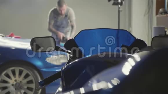 运动自行车的前景和主人抛光深蓝色汽车视频的预览图
