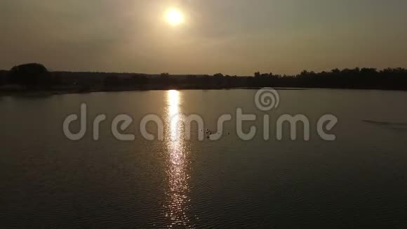 空中拍摄了一个湖有一条阳光普照的小路黑和一个游泳的人视频的预览图