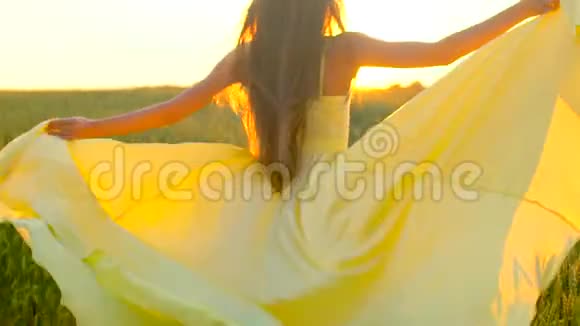 夕阳西下的夏日穿着黄色衣服在麦田里奔跑的年轻美女自由健康幸福的理念视频的预览图
