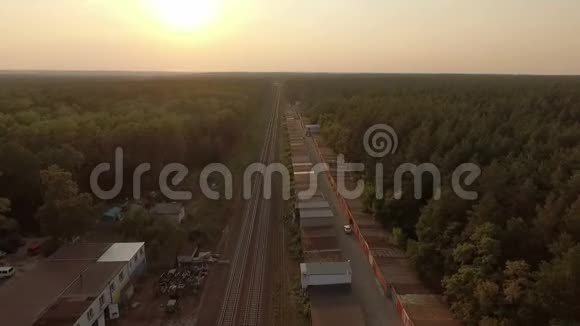 一条铁路在夏天沿着一片茂密的松树林进行空中拍摄视频的预览图
