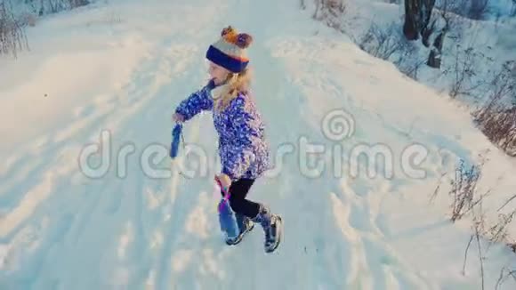 5岁的女孩在雪地上奔跑做滑稽的脸笑视频的预览图