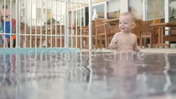 这孩子在街上游泳池里走来走去他喜欢喝水玩水滴视频的预览图