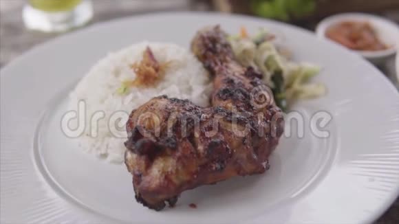 餐厅用蒸饭烤鸡腿餐盘上有鸡肉米饭上有木桌视频的预览图