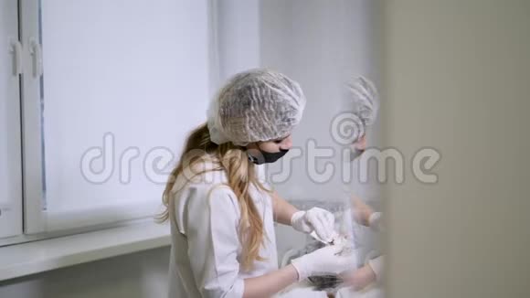 医生美容师从他躺着的病人脸上取出白色的奶油视频的预览图