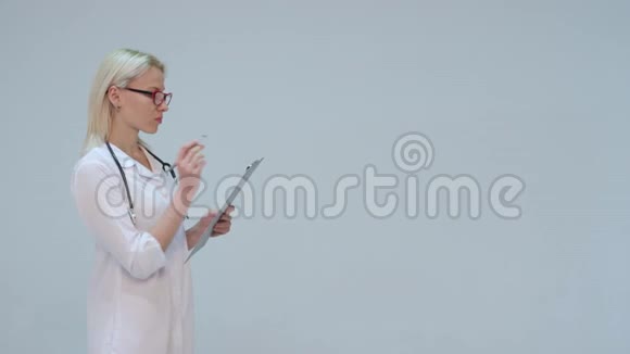 女医生穿着白色晨衣听诊器微笑记录仪器视频的预览图