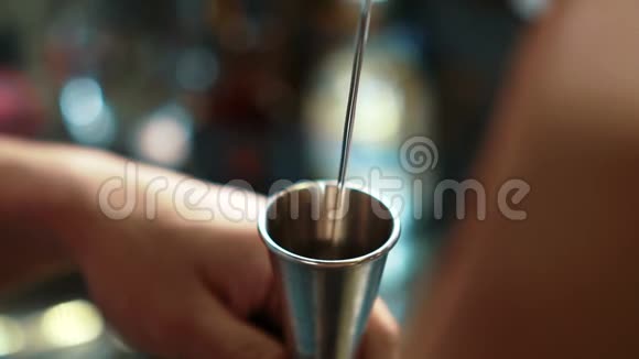 年轻的酒保把饮料倒进时髦酒吧柜台的玻璃杯里视频的预览图