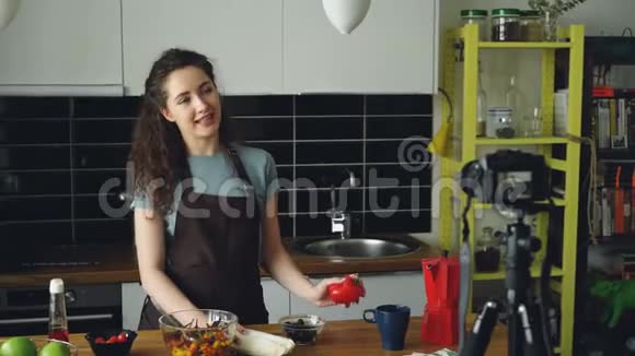 快乐迷人的女人在家里用数码相机录制关于健康烹饪的视频食物视频的预览图