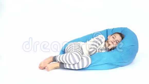 小男孩睡在白色背景的豆袋上视频的预览图