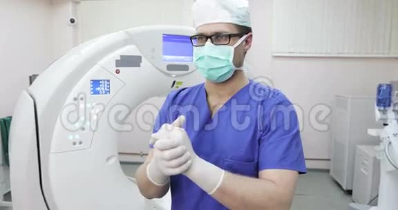 4一位戴口罩的年轻医生放射科医生纠正了医疗手套视频的预览图