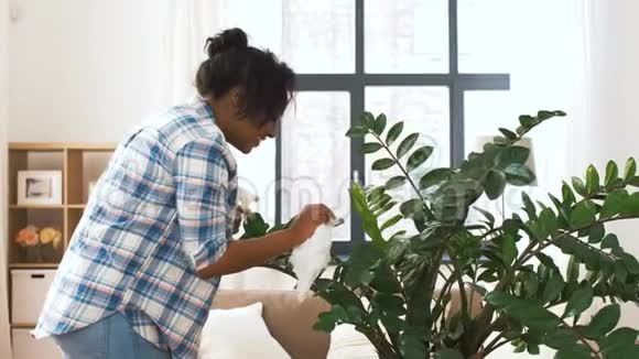 快乐的女人在家里打扫家里的植物视频的预览图