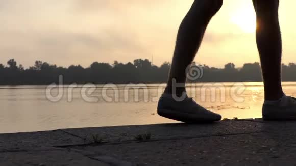 雄腿在夏日夕阳下的河岸边散步跳舞视频的预览图