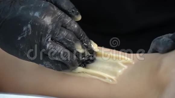 有一个女人脚把糖块撕下来用来脱毛这是一个糖精会照顾腿的健康视频的预览图