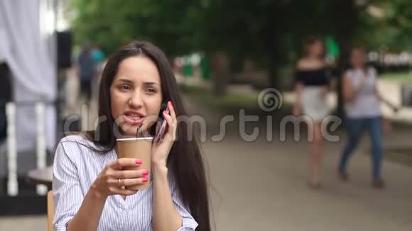 现代女孩在户外咖啡馆打电话视频的预览图