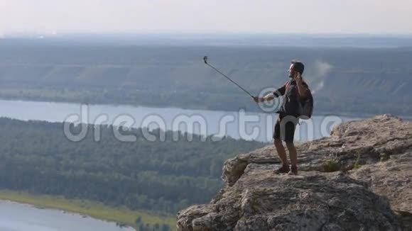 无畏的旅行者在山顶上用照相机拍摄自己视频的预览图