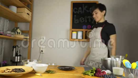 女孩在厨房做饭准备巧克力蛋糕视频的预览图