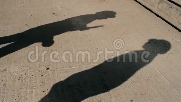两个人在水泥地上的影子视频的预览图