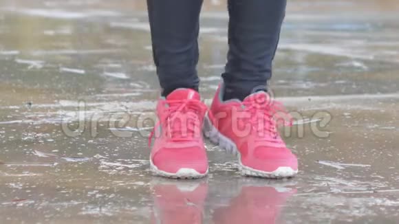 玫瑰运动鞋中女性脚的特写镜头女人在雨中跳上一根绳子视频的预览图