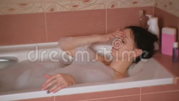 年轻漂亮的女人在洗澡的时候休息视频的预览图