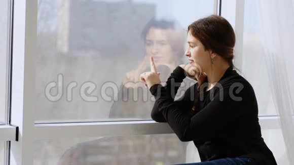 女人在窗外画心指和浪漫的叹息视频的预览图