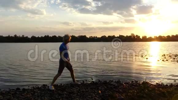 灿烂的日落和一个男孩扔平石头在河水在4k视频的预览图