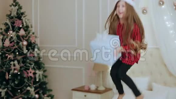 快乐的小女孩带着礼品盒跳上床视频的预览图