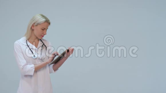 快乐而微笑的年轻医生在药片上打字视频的预览图
