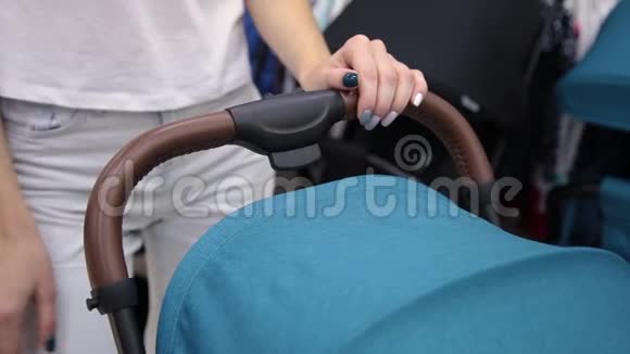 一个女人手牵着一辆婴儿马车特写视频的预览图
