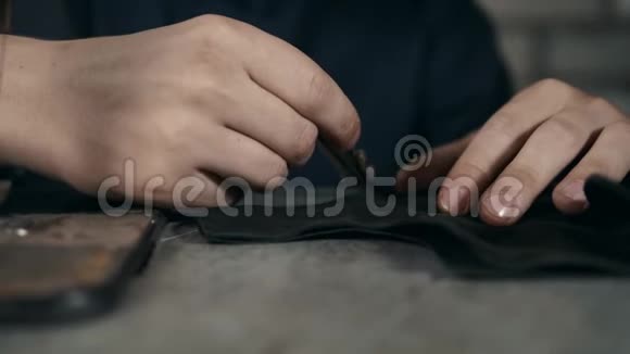 鞋匠在车间做皮鞋男士特写镜头机器宏胶厂靴子手工制作视频的预览图