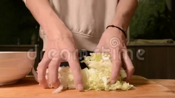 一个女孩在家厨房里用木切割板把皮金斯基卷心菜切成沙拉家庭视频的预览图