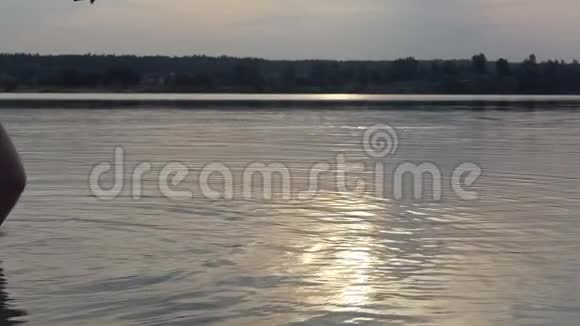 年轻人扔了一颗鹅卵石在斯洛莫的湖水上跳跃视频的预览图