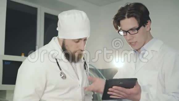 两名医生在诊所使用片剂咨询4K视频的预览图
