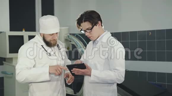 两名医生在诊所使用片剂咨询4K视频的预览图