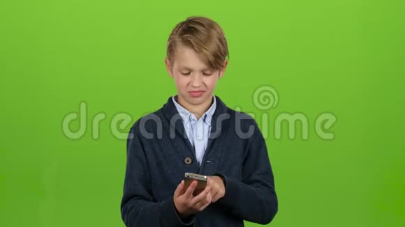 孩子用大拇指指着手机上的照片绿色屏幕视频的预览图