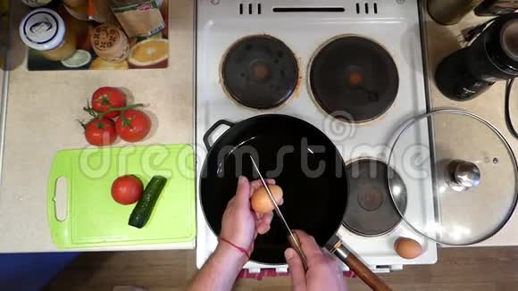 雄手在煎锅上用尖刀切鸡蛋视频的预览图