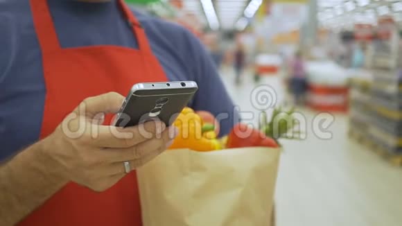 超市员工用手机拿着购物袋视频的预览图