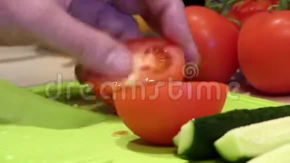 一只雄性手在桌子上切西红柿和黄瓜视频的预览图