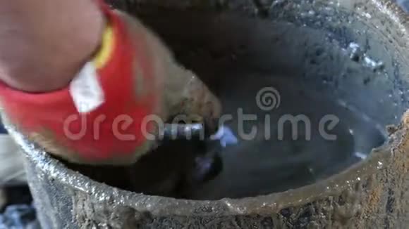 一只雄性手在手套中混合水泥和水来获得砂浆视频的预览图