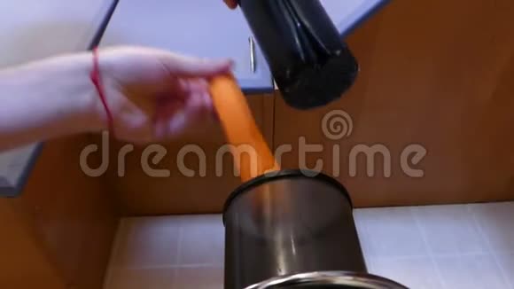 一只雄性手把胡萝卜放进果汁机里得到果汁视频的预览图