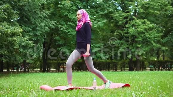 夏季公园里蹲着哑铃的穆斯林年轻女子视频的预览图