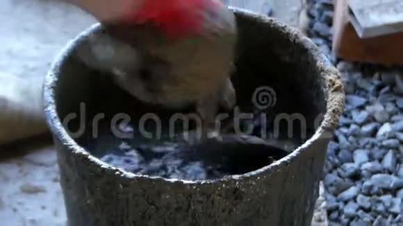 人把水泥和水混合在桶里得到灰色的灰浆视频的预览图